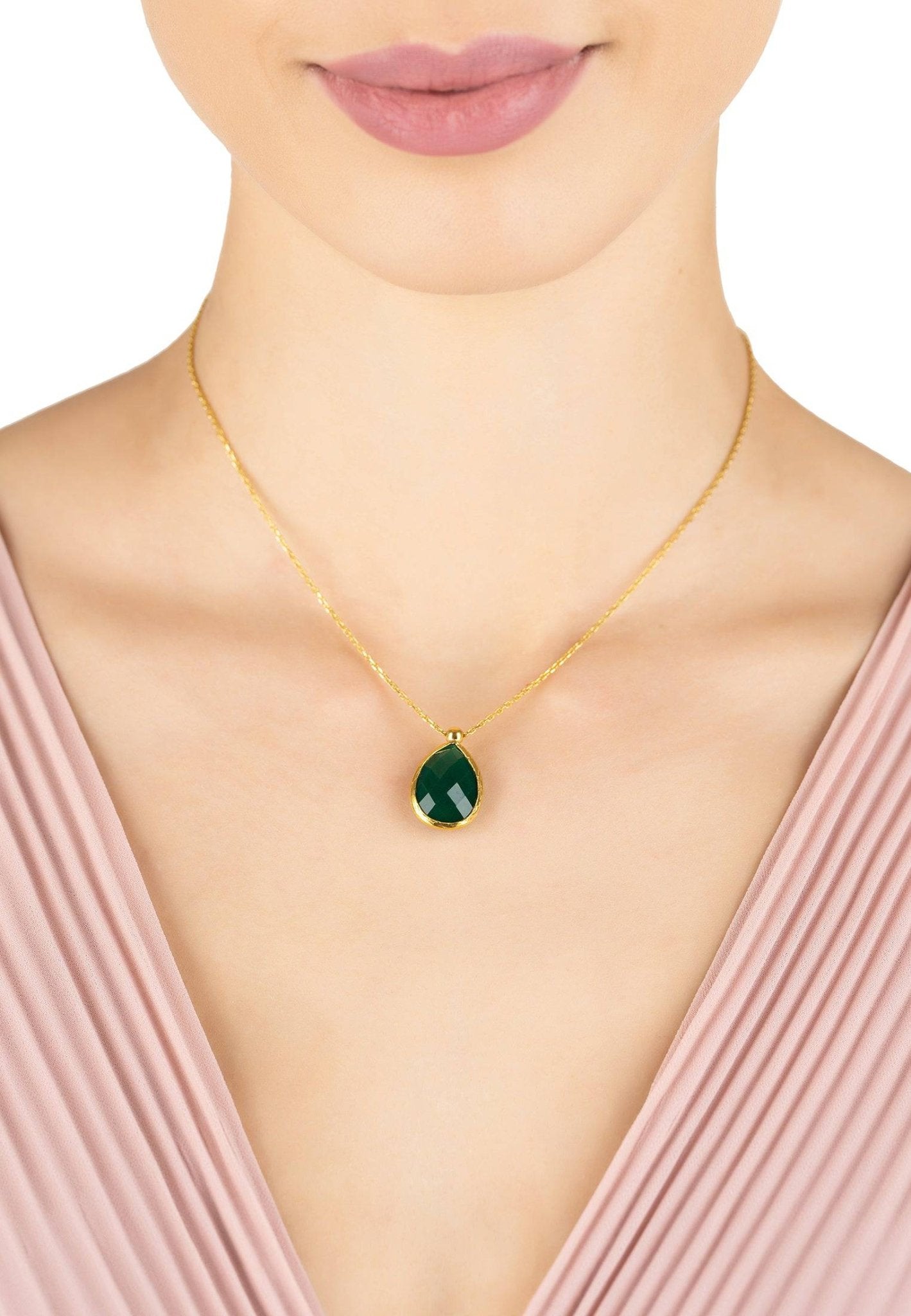 Gold necklace with Green Onyx gemstone displayed on a jewelry stand