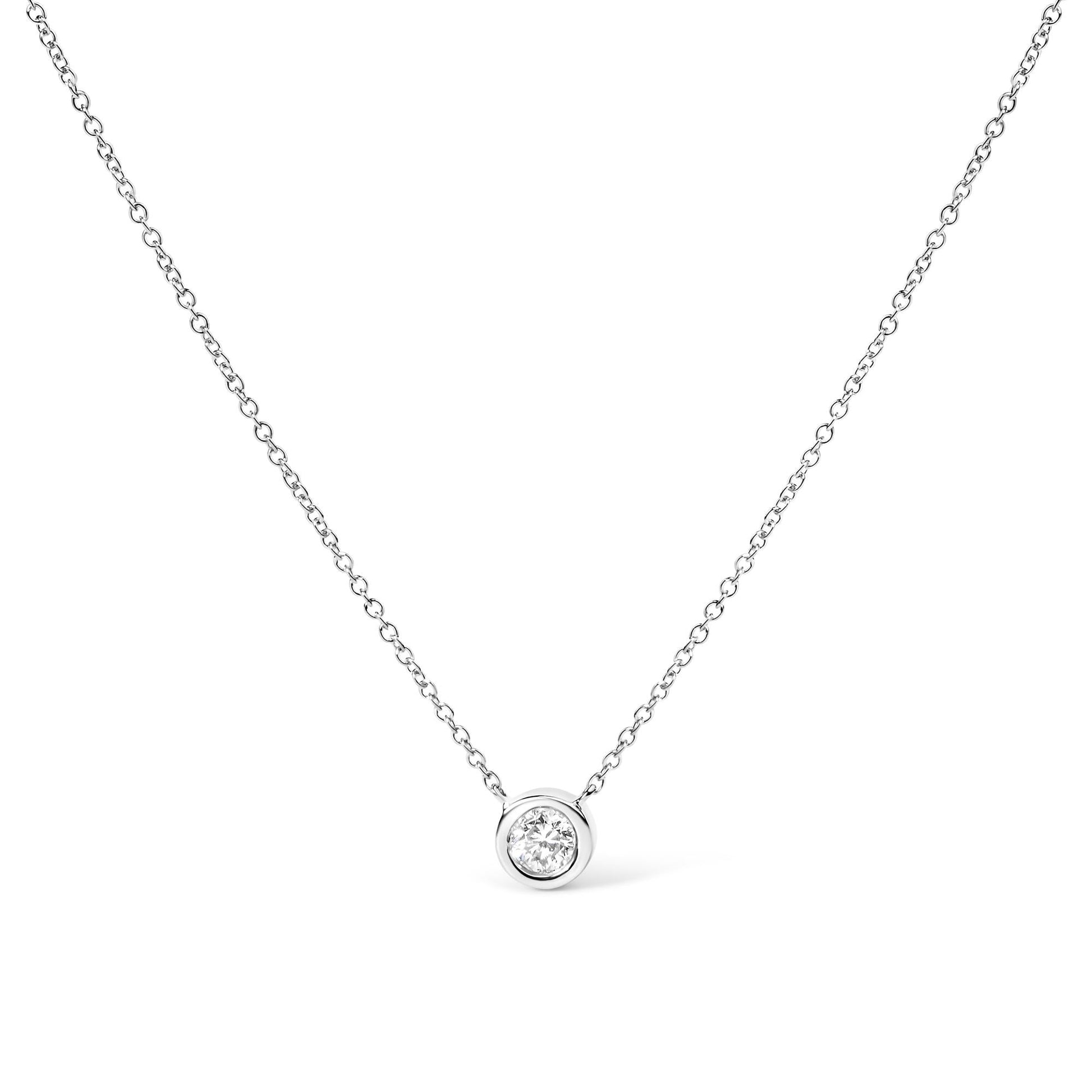 A 14K gold lab grown diamond solitaire bezel-set pendant necklace with an adjustable chain.